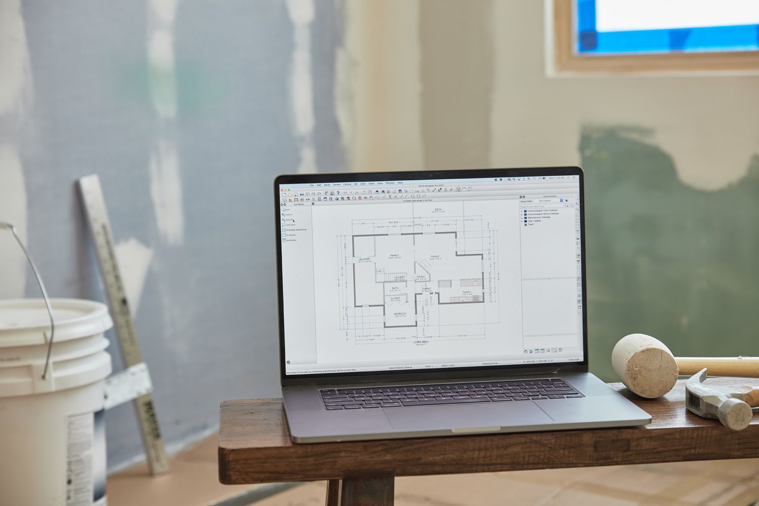 House floor-plan on computer in middle of room being renovated