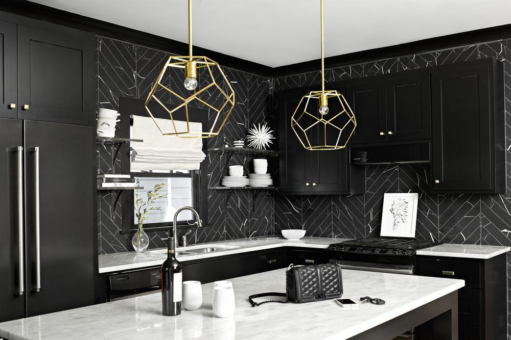 Cocina de azulejos negros con armarios negros y detalles plateados y dorados