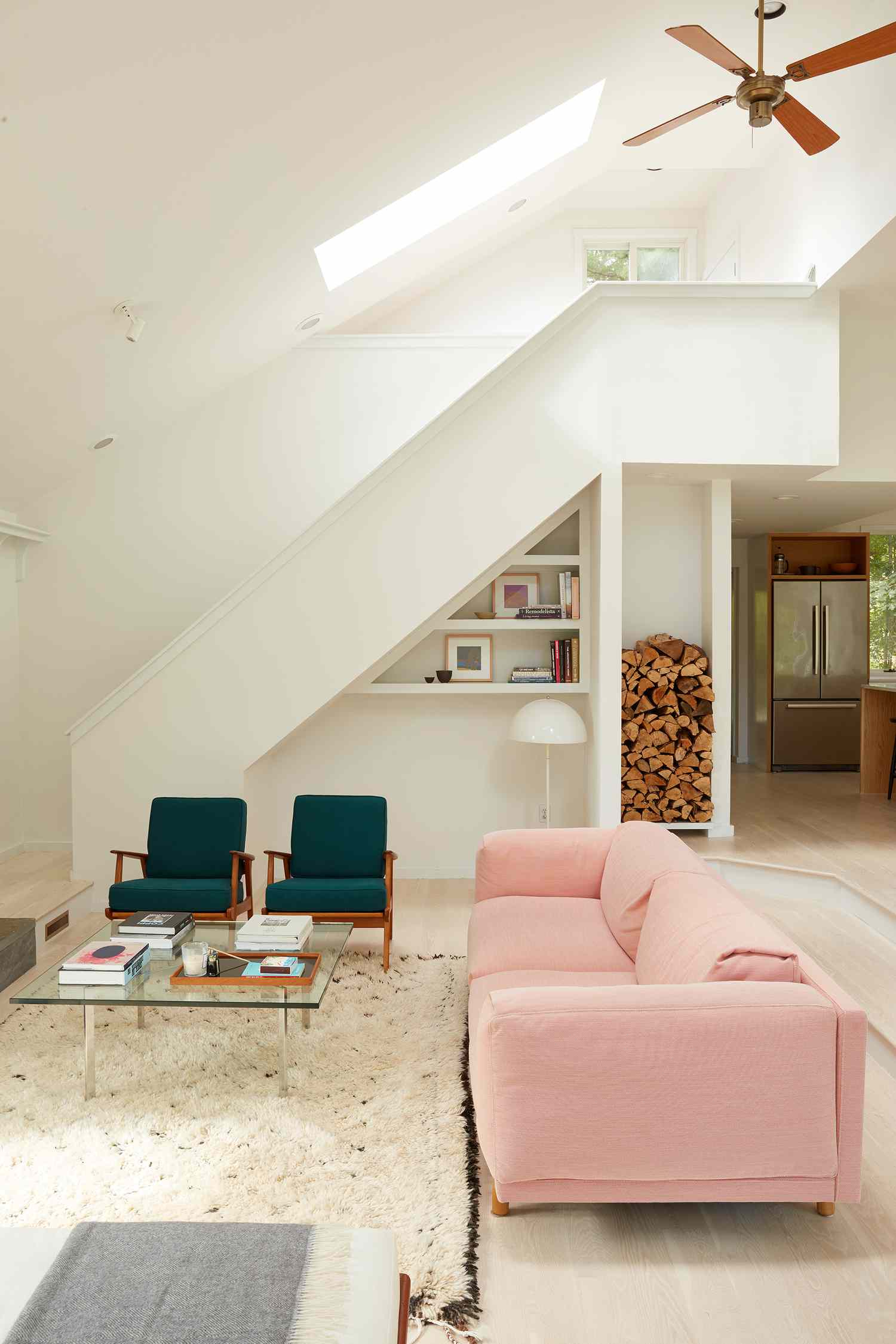 Weißes Zimmer mit rosa Sofa und tealfarbenen Stühlen