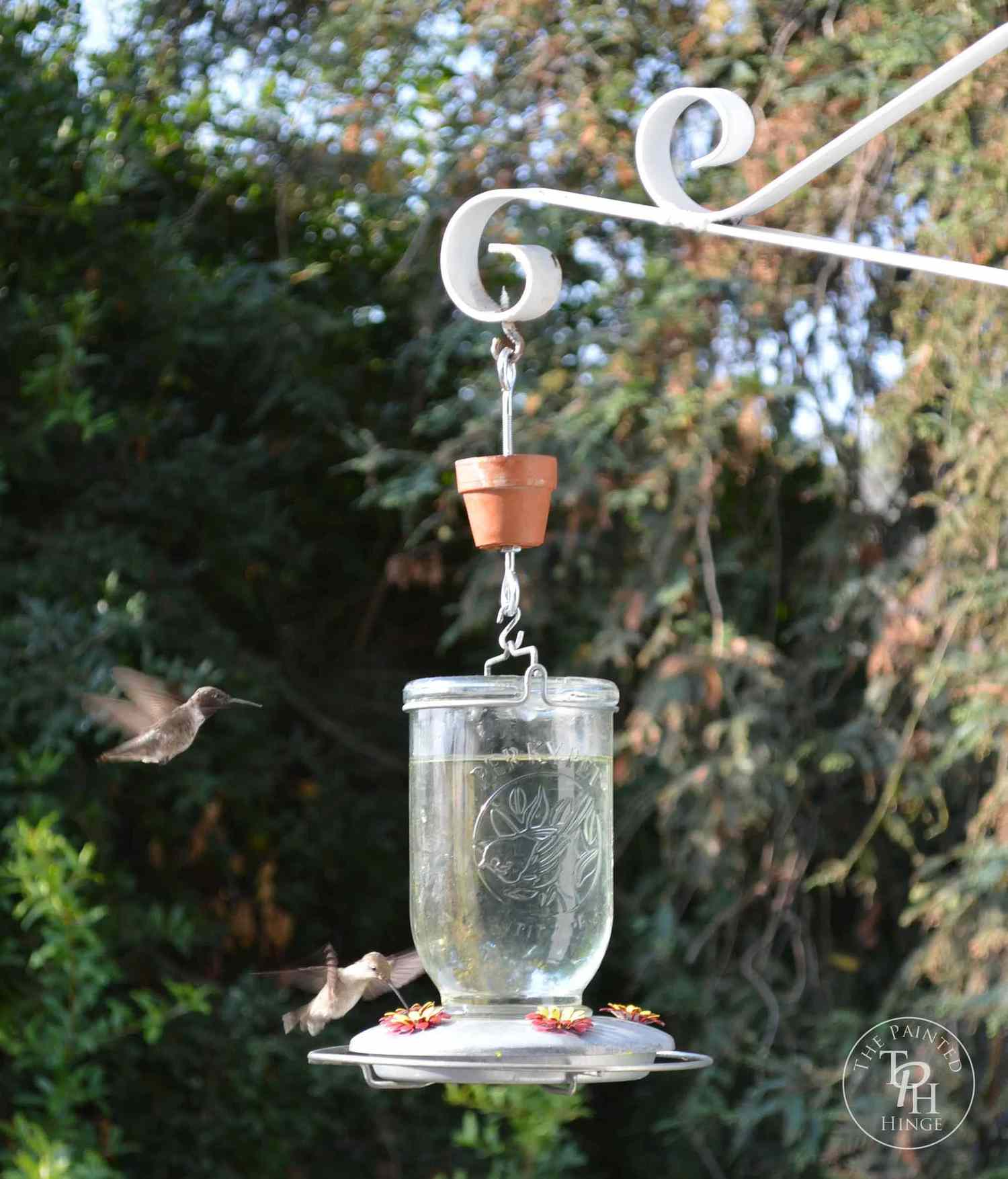 A hummingbird feeder with hummingbirds