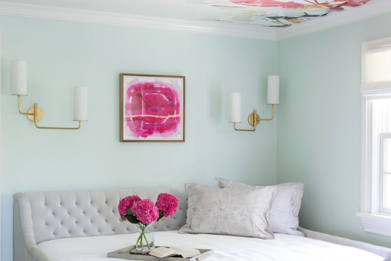 Schlafzimmer mit hellblauen Wänden und pinkfarbenen Akzenten, mit pinkfarbener Blumenwand an der Decke