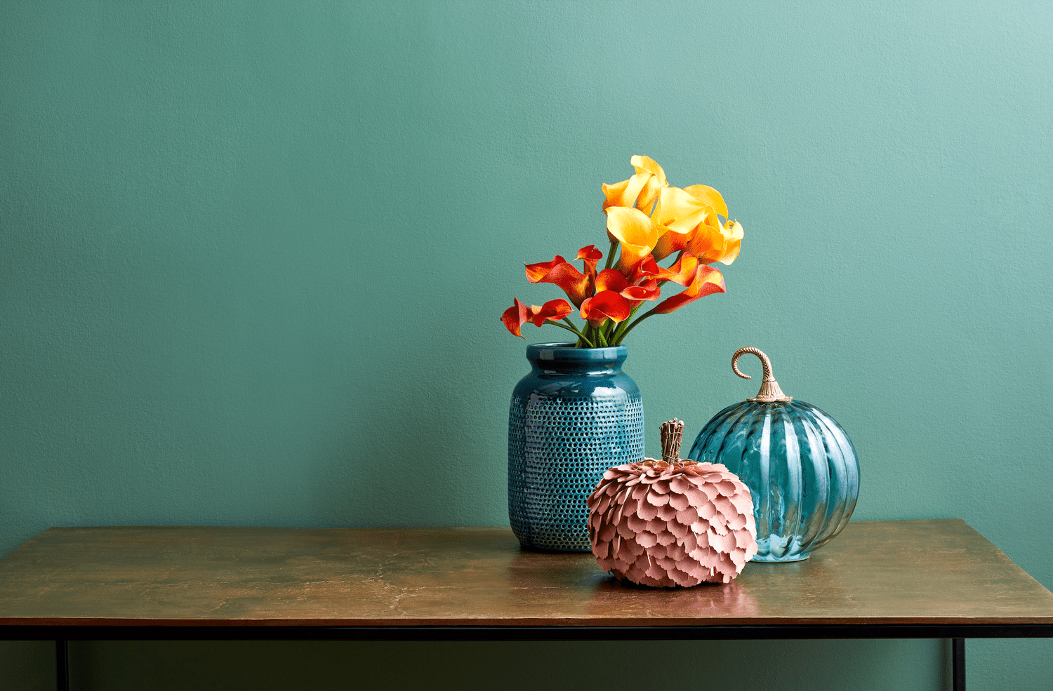 Eine Sammlung von Zierkürbissen und Blumen auf einer Tischplatte