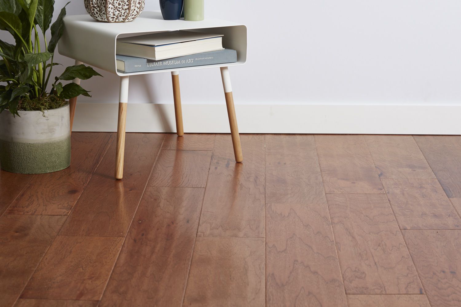 Parquet con planta de interior y mesa auxiliar con libros