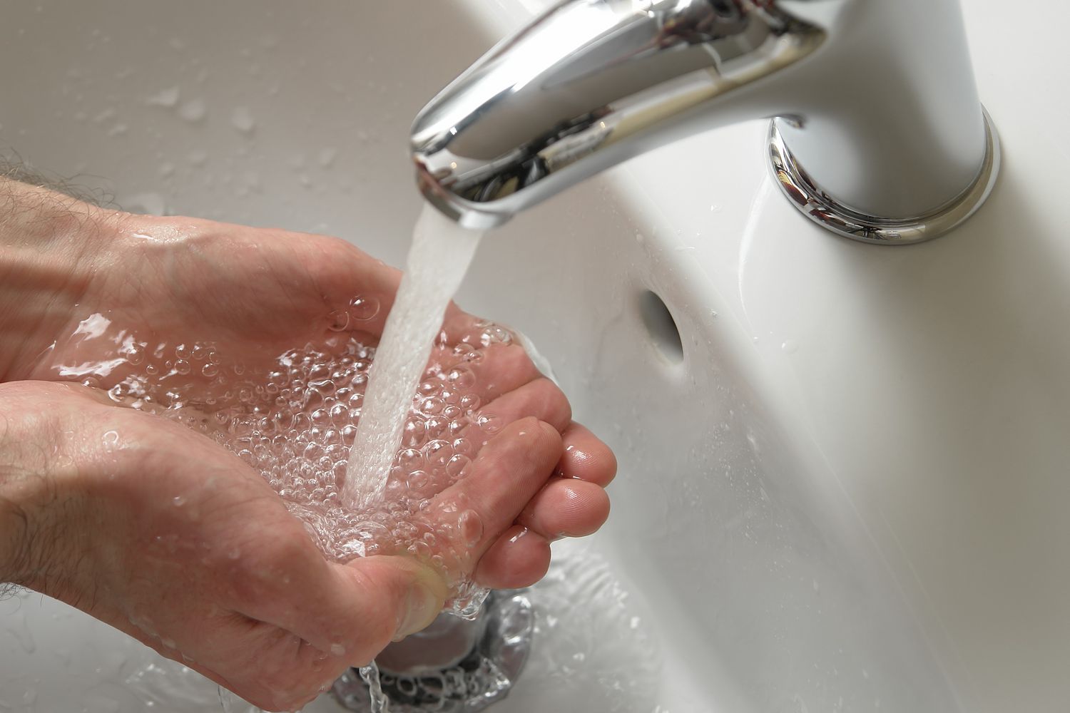 Wasserhahn mit Händen