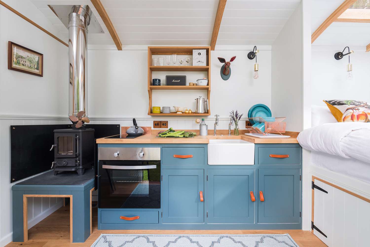 Tiny house kitchen with bright blue cabinets and leather hardware