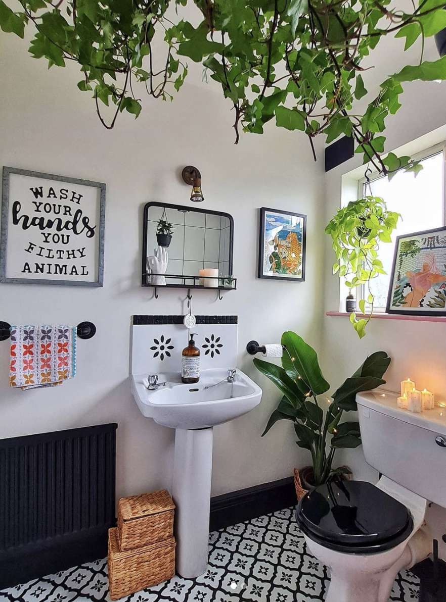 banheiro eclético com obras de arte e plantas