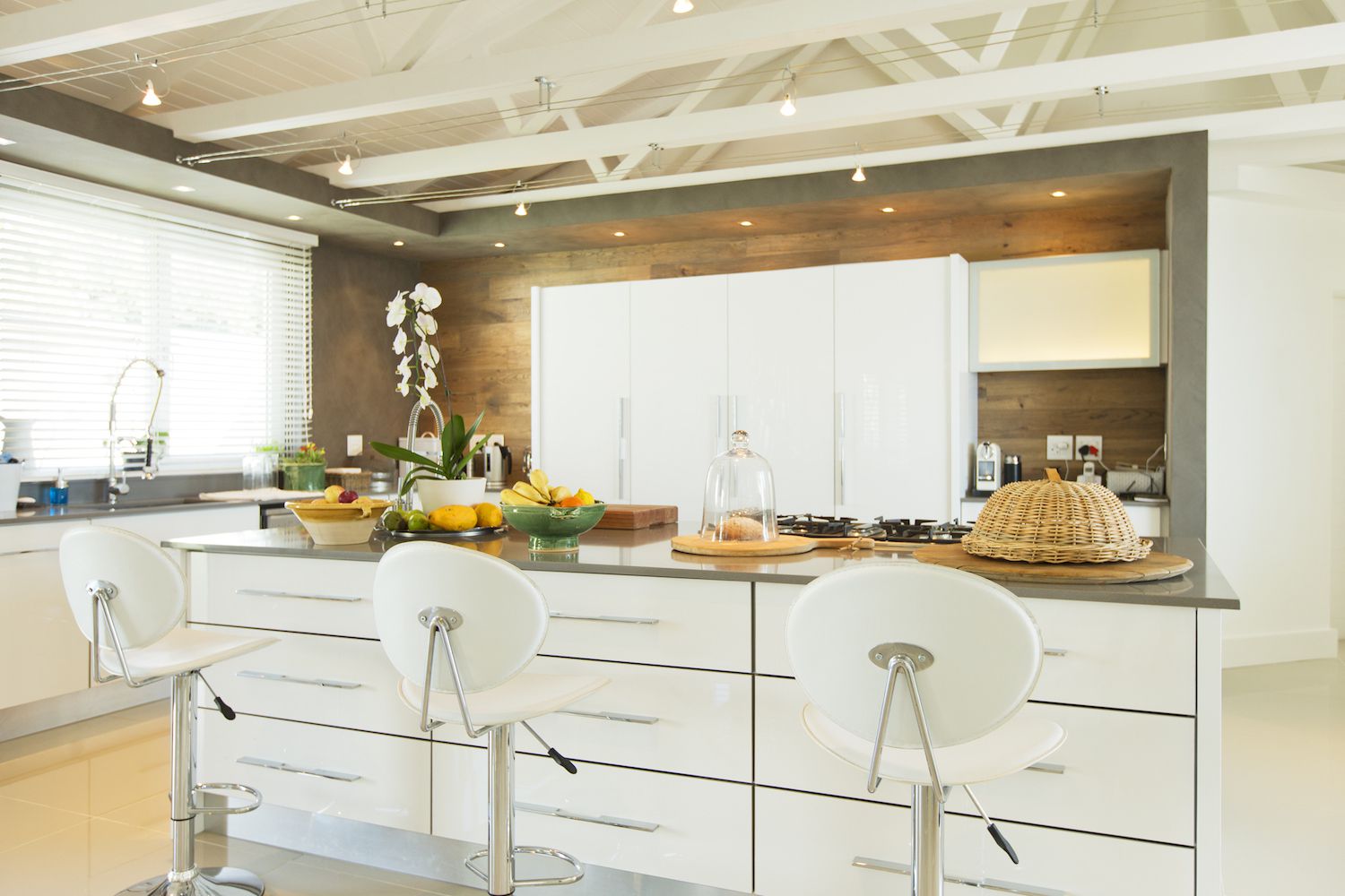 Uma cozinha decorada em branco, marrom e cinza