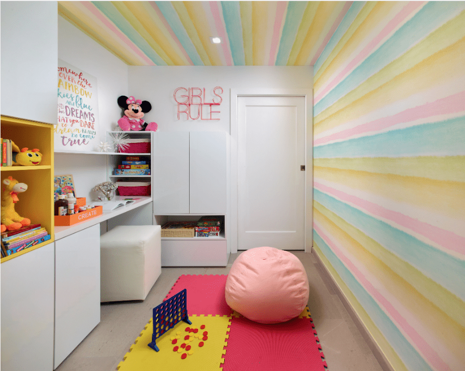 Un papier peint mural à rayures pastel s'étend jusqu'au plafond dans la chambre de cette jeune fille