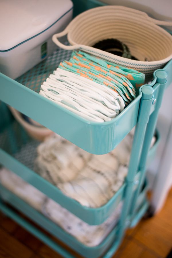 Ikea's Raskog utility cart in turquoise being used as a diaper caddy