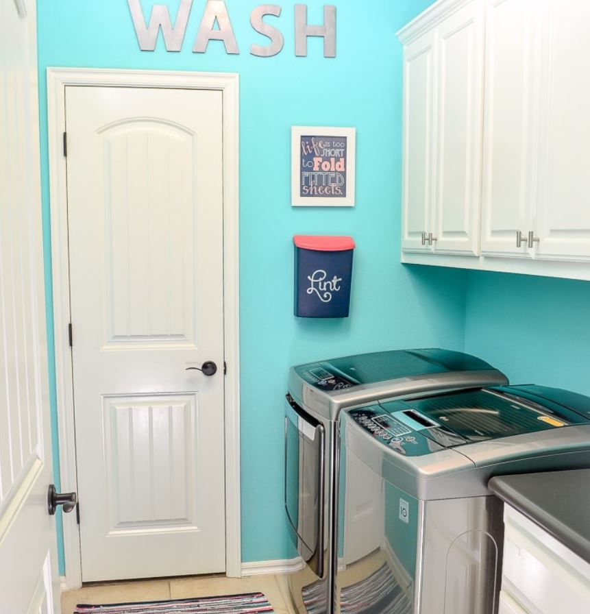 Kleine Waschküche mit türkisfarbenen Wänden.