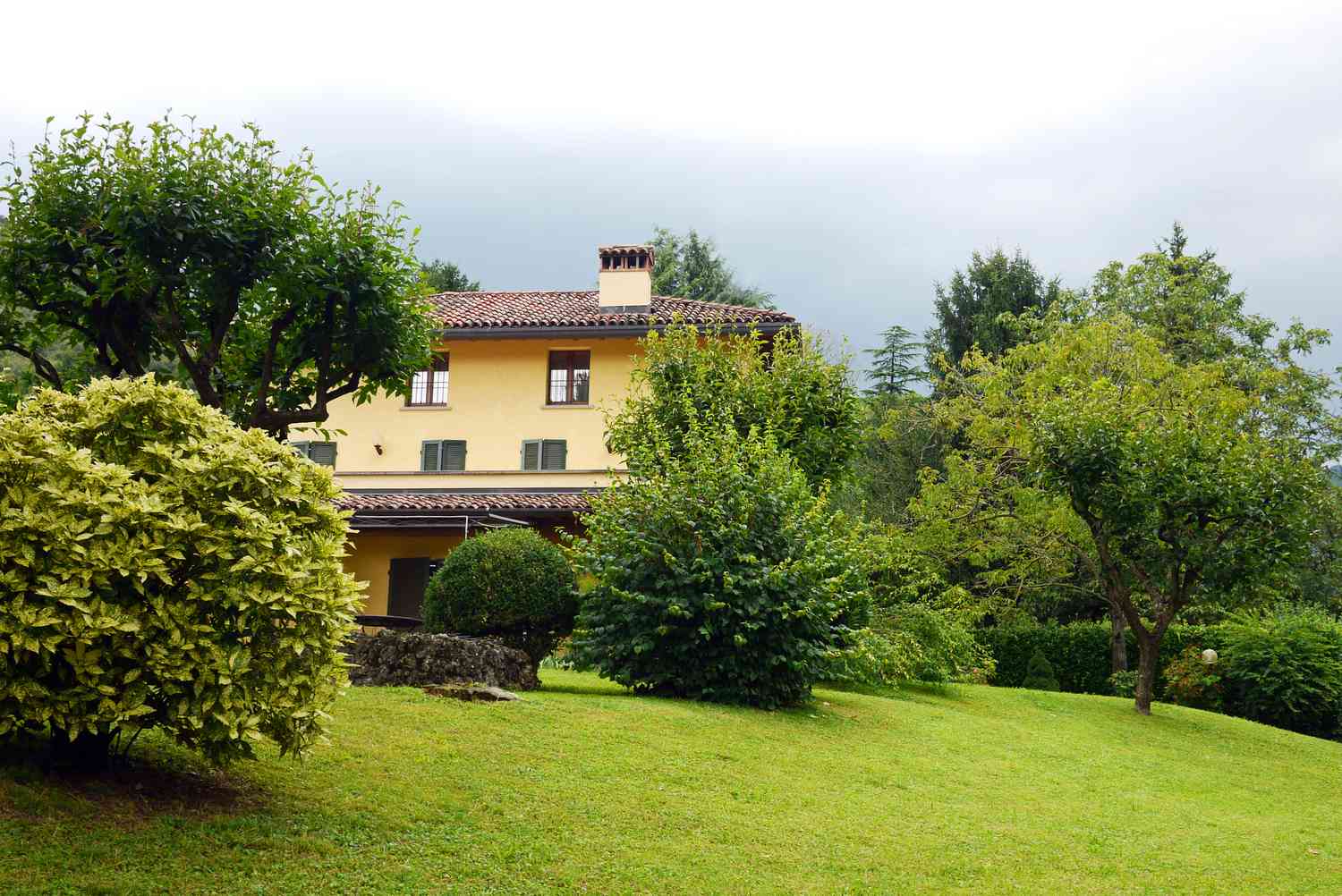 Arbustos y árboles dan intimidad a esta casa italiana.