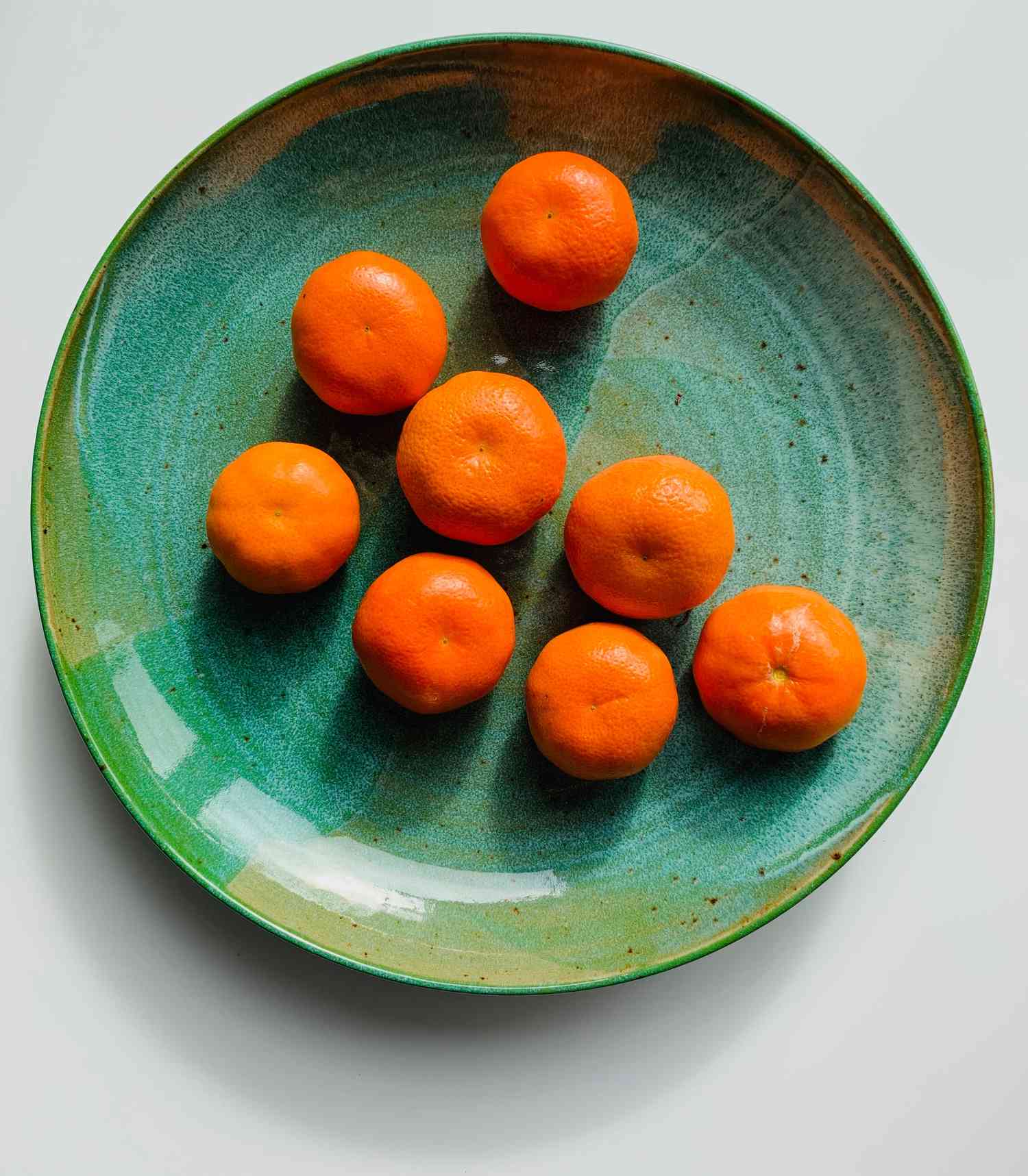 orange tangerines on a green plate