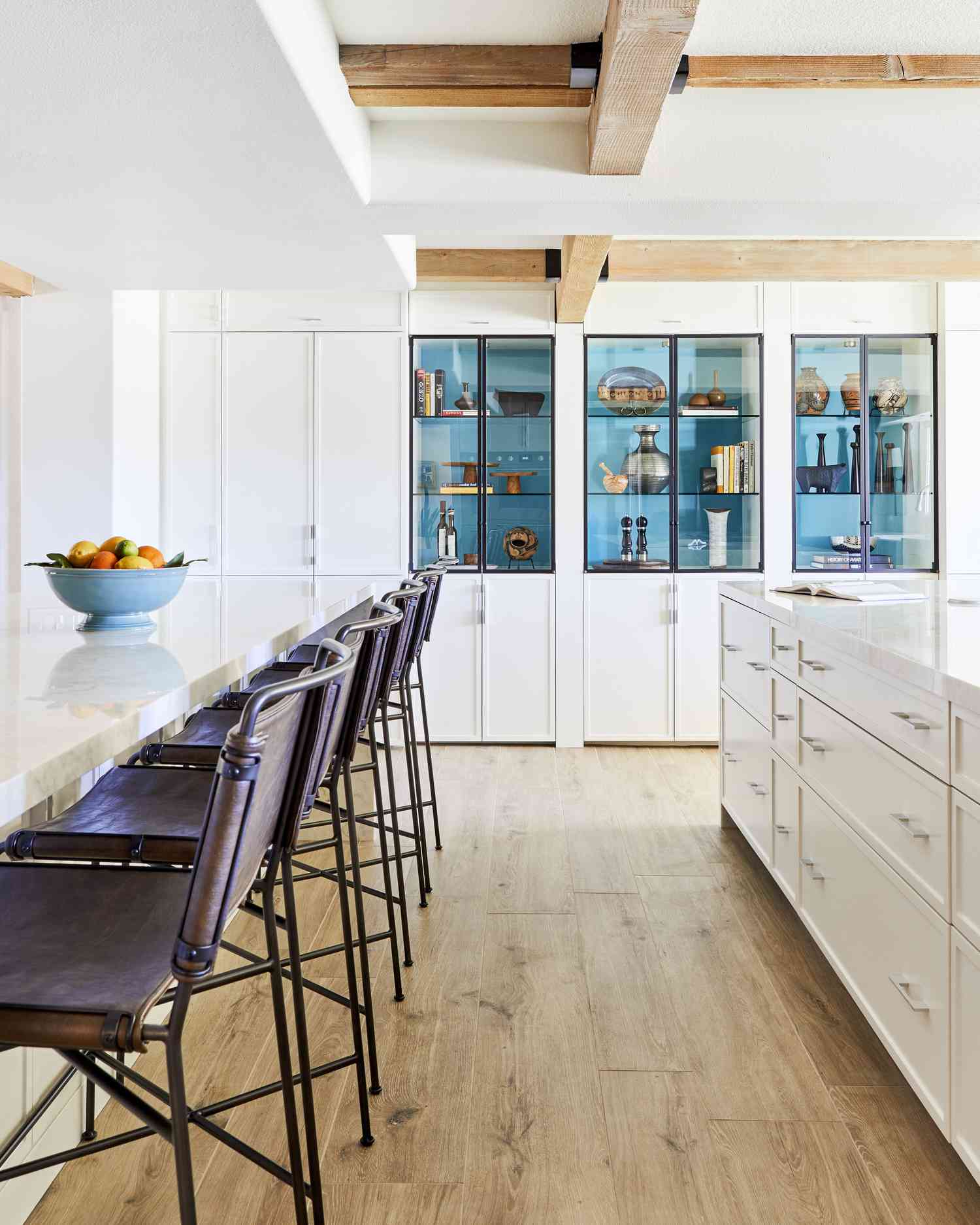 las paredes blancas de esta cocina ayudan a resaltar el azul de las estanterías