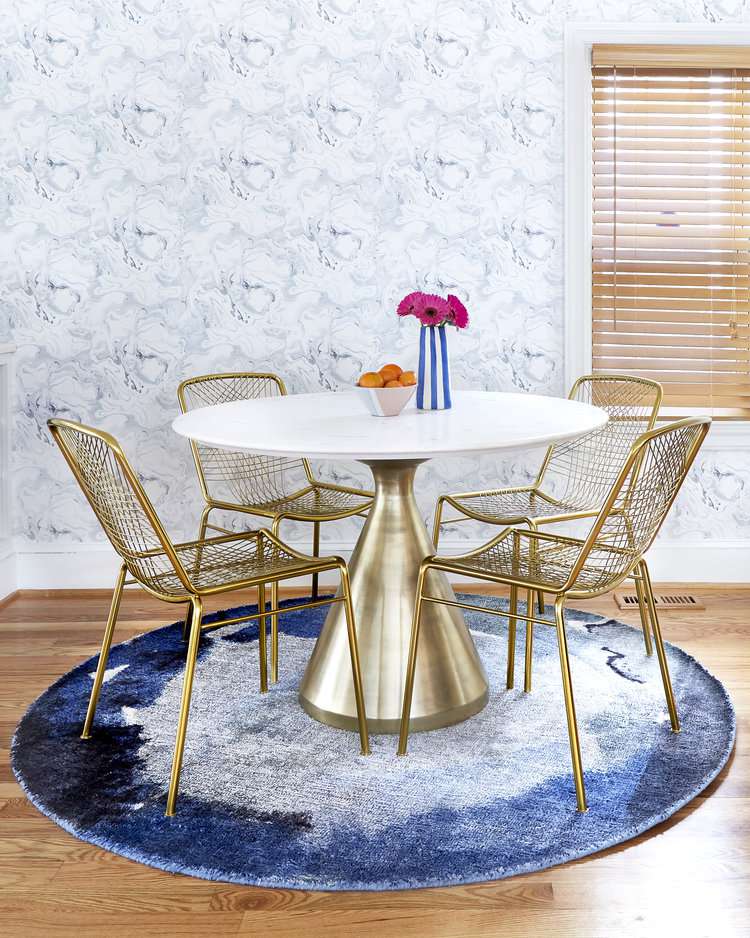 table ronde et chaises en laiton dans salle à manger bleue