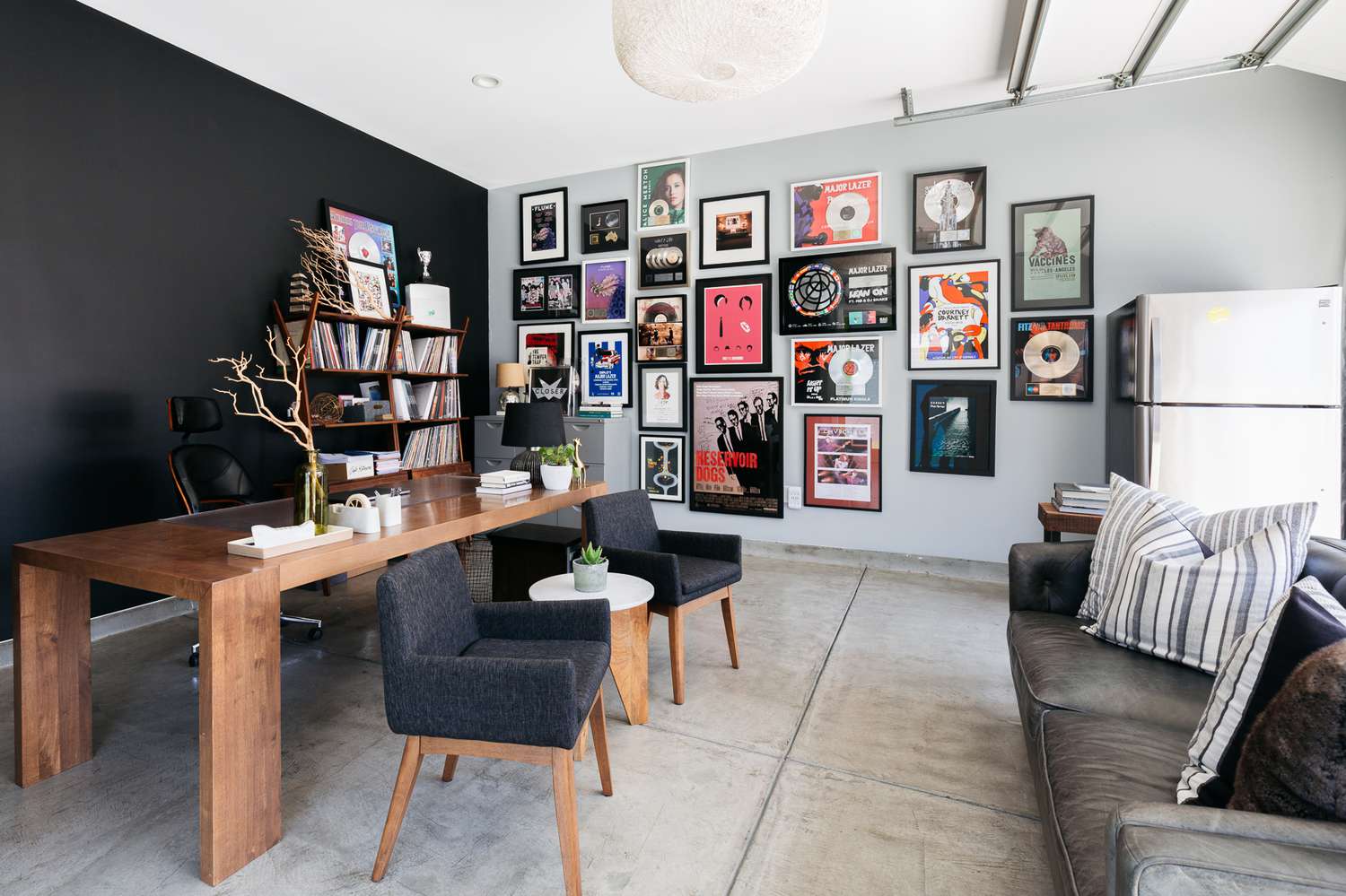 Modernes Zimmer im rauen Stil mit Holzesstisch und bunten Kunstwerken