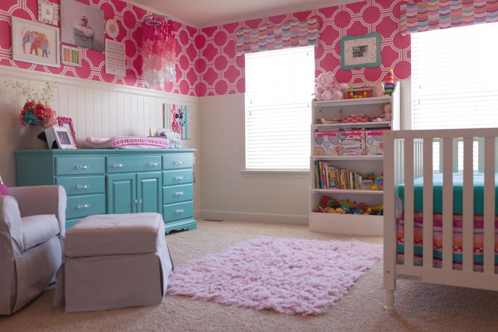Colorida habitación infantil en rosa fuerte y cerceta con atrevidos toques geométricos