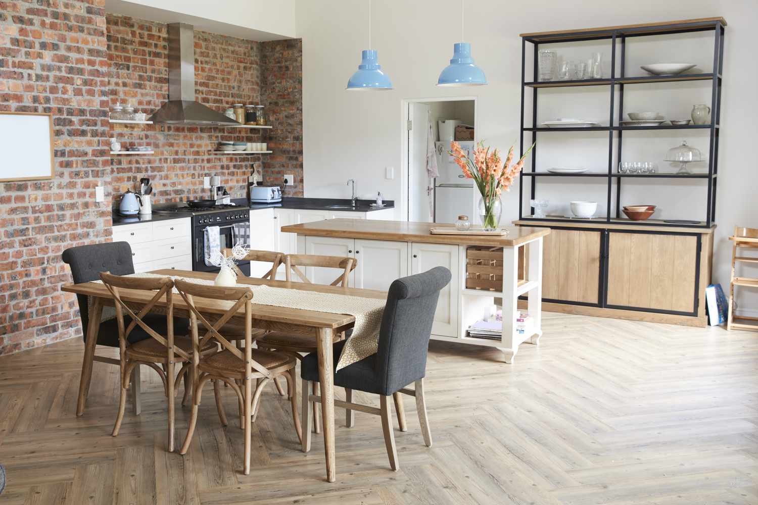 Stilvolles Wohninterieur mit offener Küche und Essbereich mit Ziegelstein-Akzentwand