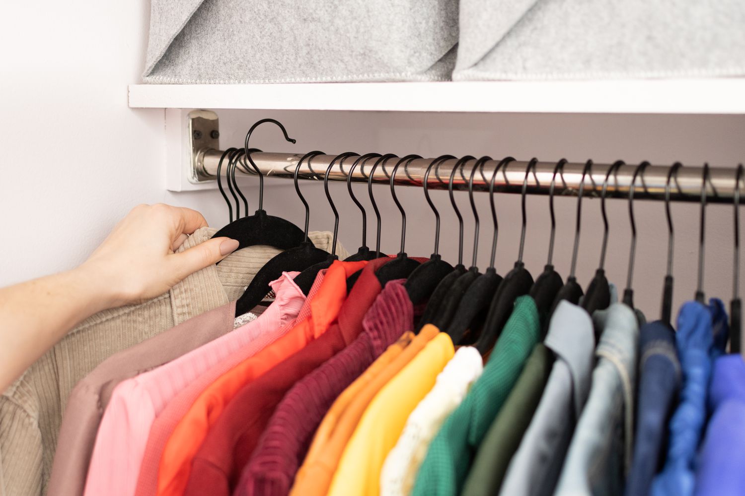 Farbcodierter Kleiderschrank auf Bügeln organisiert