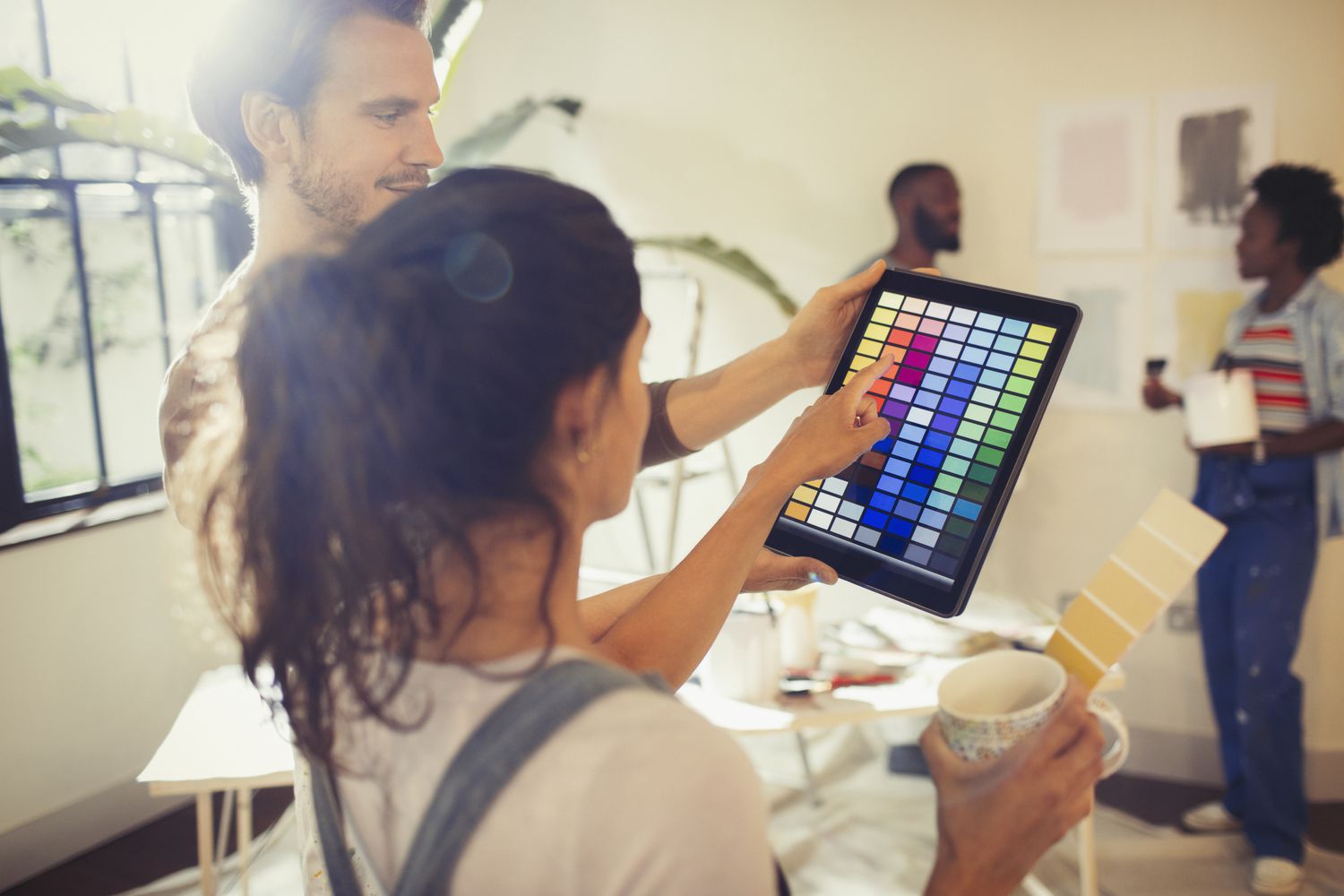 Amigos usando tablet para amostras de cores de tintas
