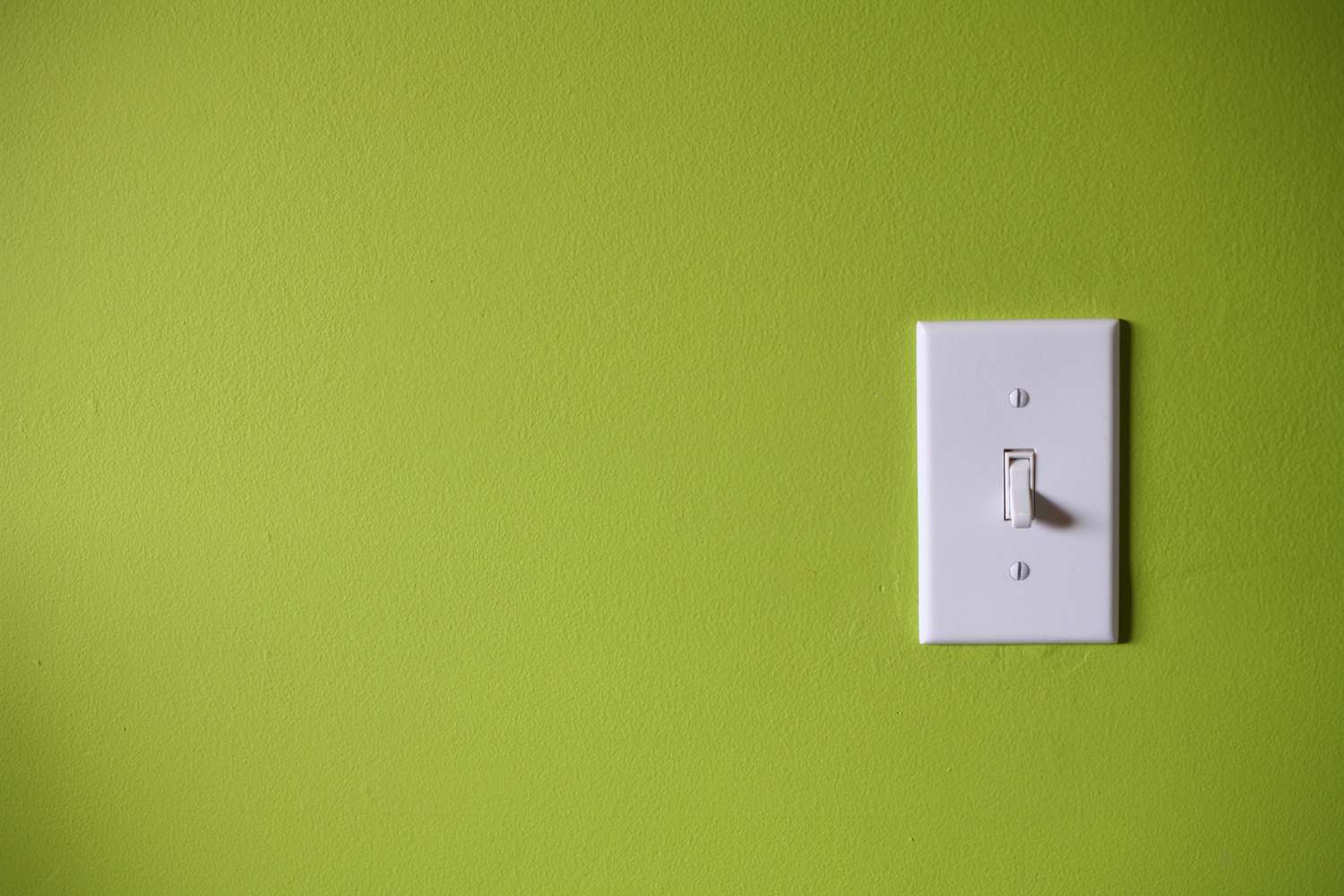 Interruptor de la luz delante de un fondo verde