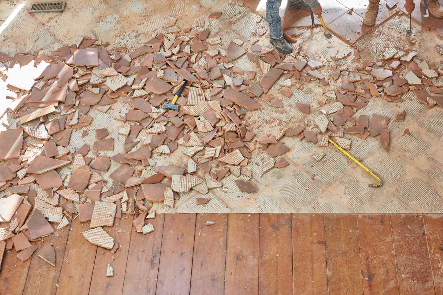 Tile flooring demolished next to wooden flooring for house renovation