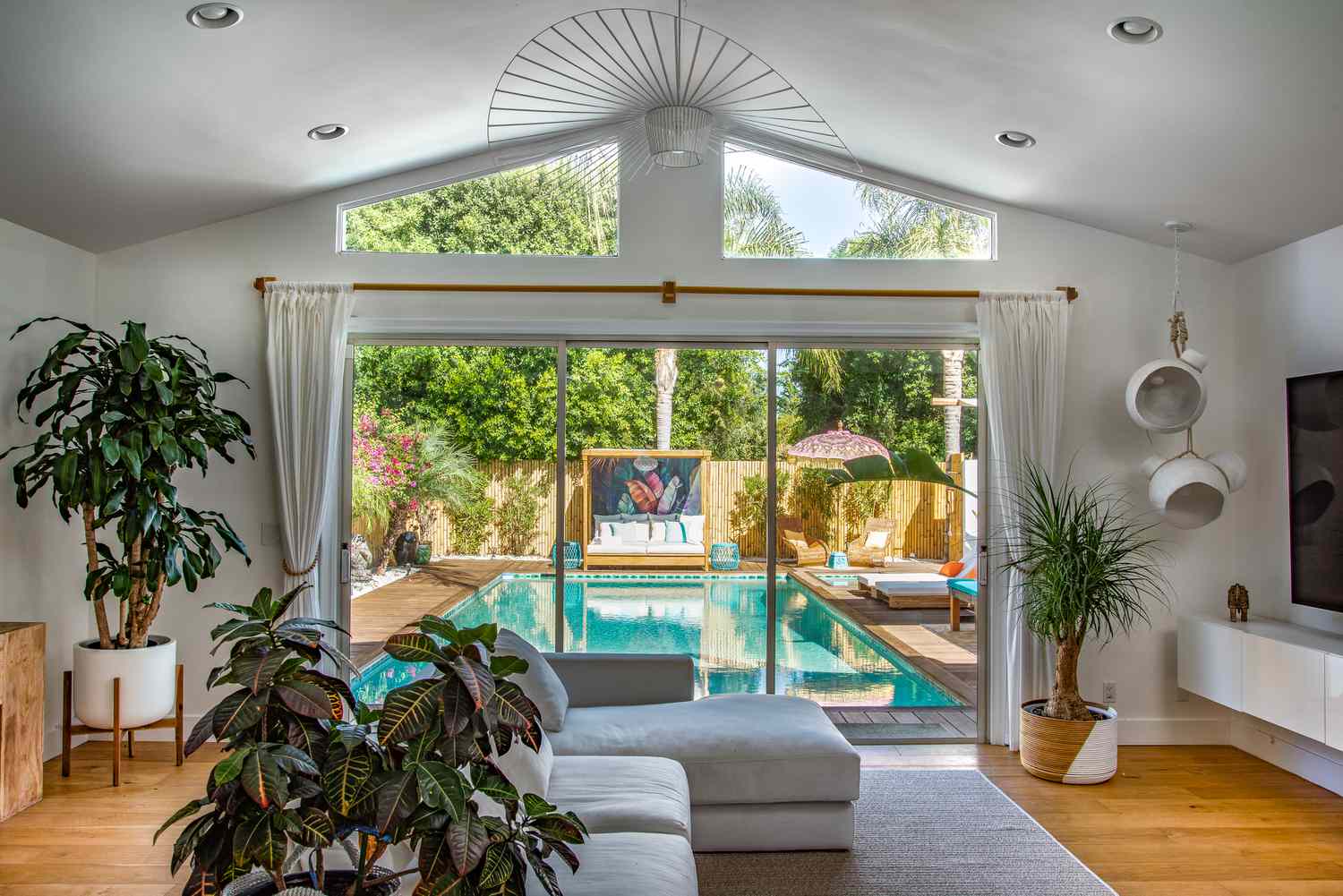 Living space with floor to ceiling window out to pool area