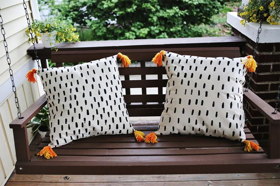 Two throw pillows on a porch swing