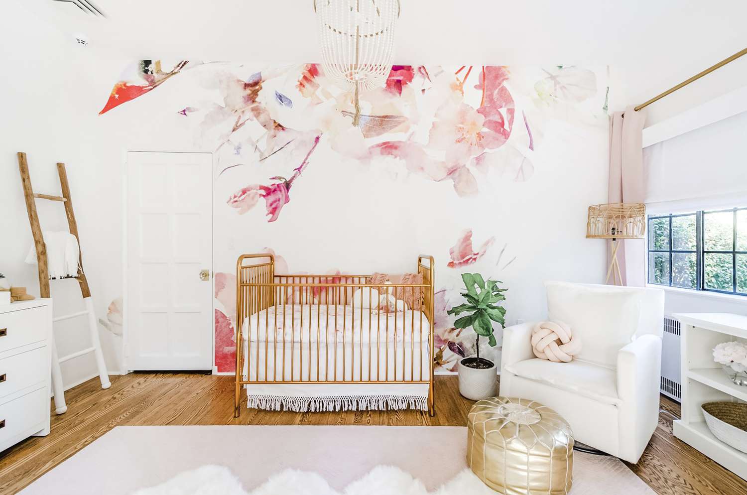 eine rosa und korallfarbene Wandtapete mit Blumen in einem weißen Kinderzimmer