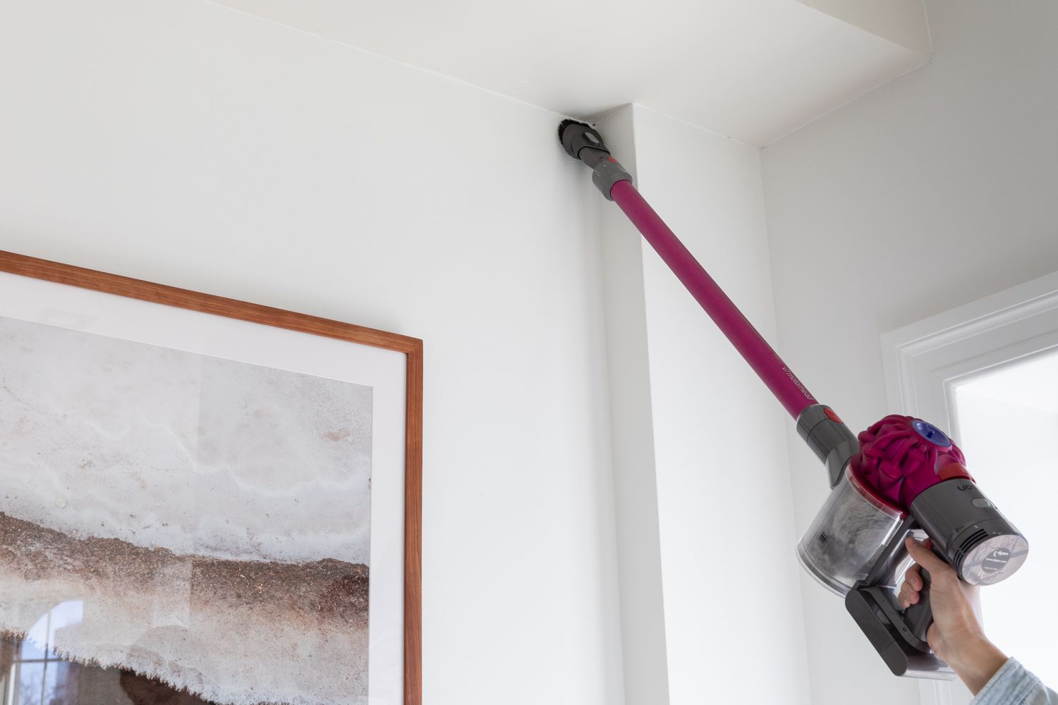 Pink hand-held vacuum cleaning roof corner