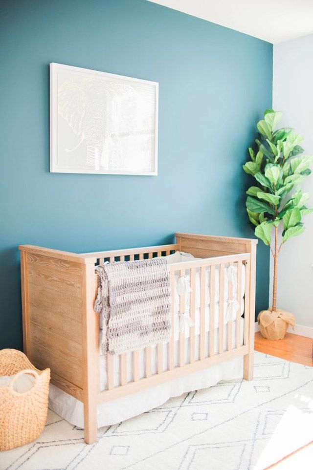 Quarto de bebê simples, de gênero neutro, com parede de realce azul-petróleo