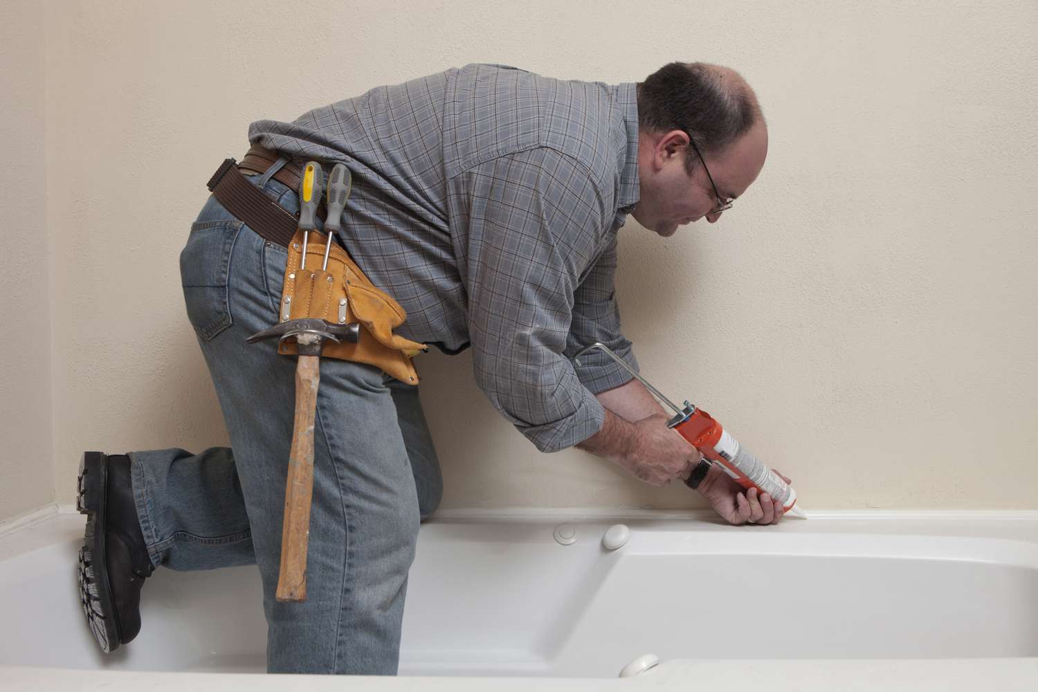 USA, Texas, Dallas, Man with Caulk Gun working in bathroom