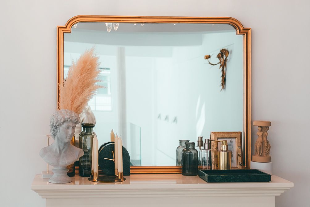 espelho grande dourado em uma lareira