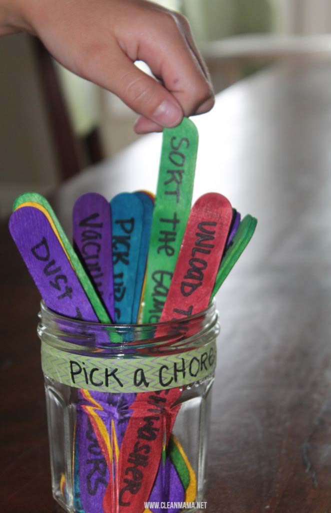 Uma criança pegando um bastão colorido em um pote