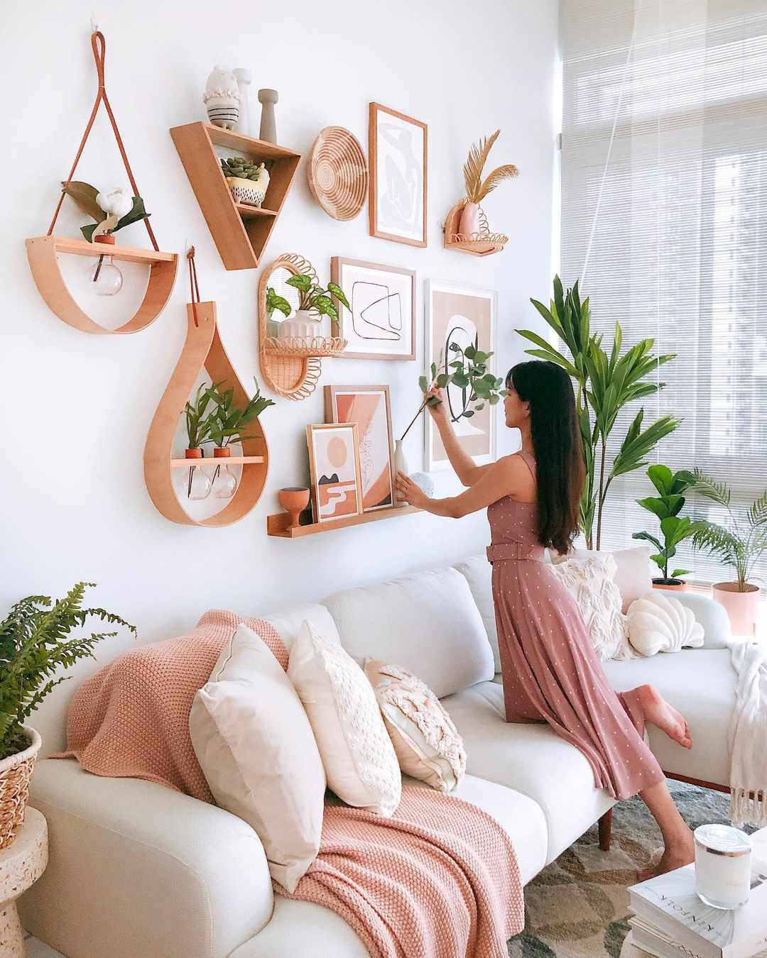 Une jeune femme plaçant une plante dans un vase dans un mur de galerie de salon