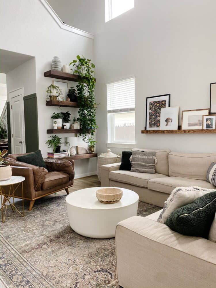 Un salon boho avec une table basse circulaire blanche et un canapé beige.