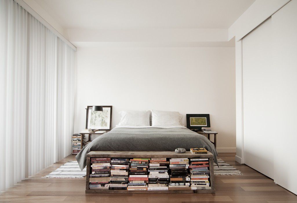 Bett mit rustikalem Bücherregal am Boden
