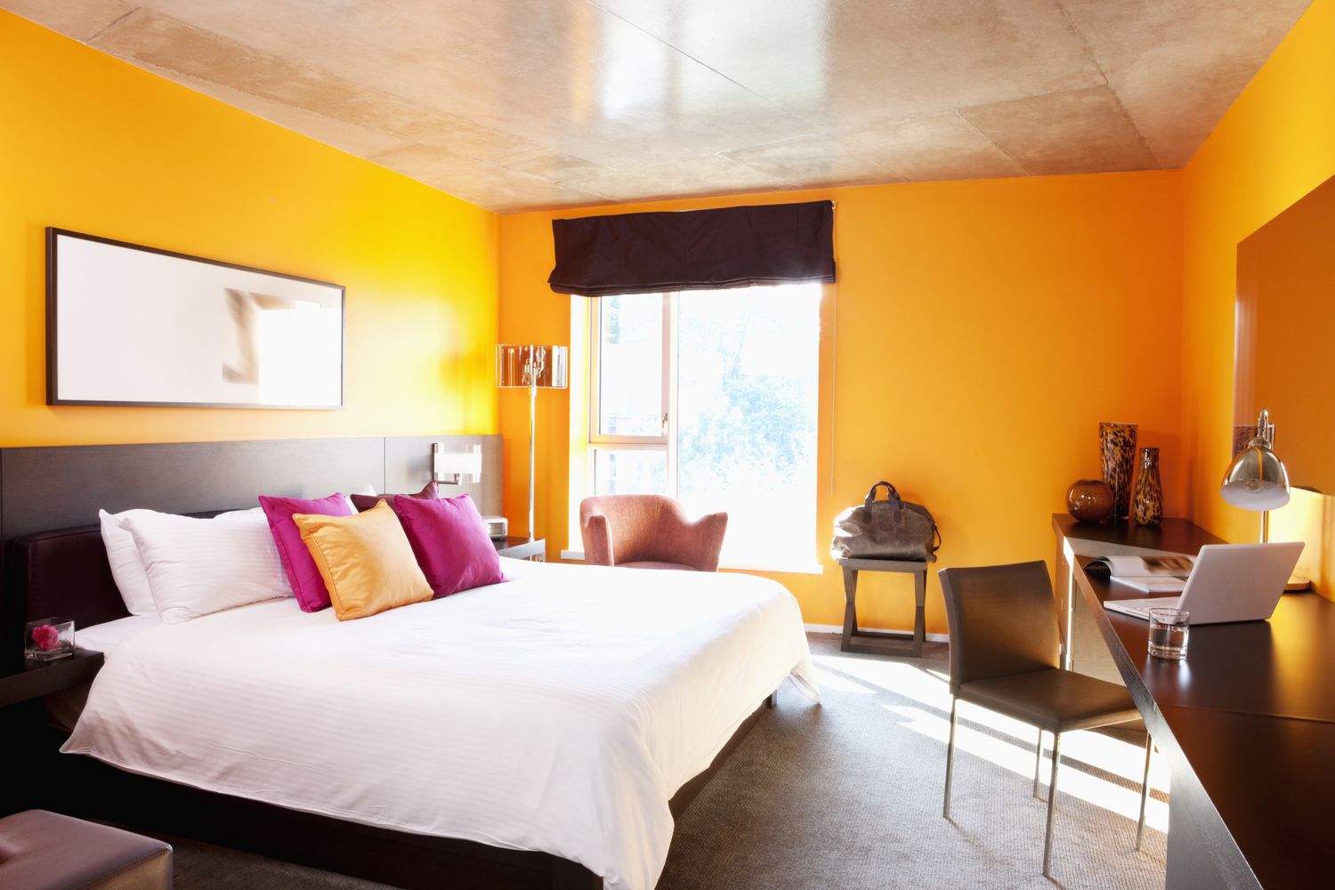 Schlafzimmer mit orangefarbenen Wänden und Akzentkissen