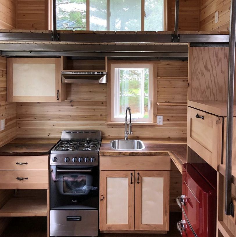 uma cozinha de casa minúscula construída principalmente de madeira