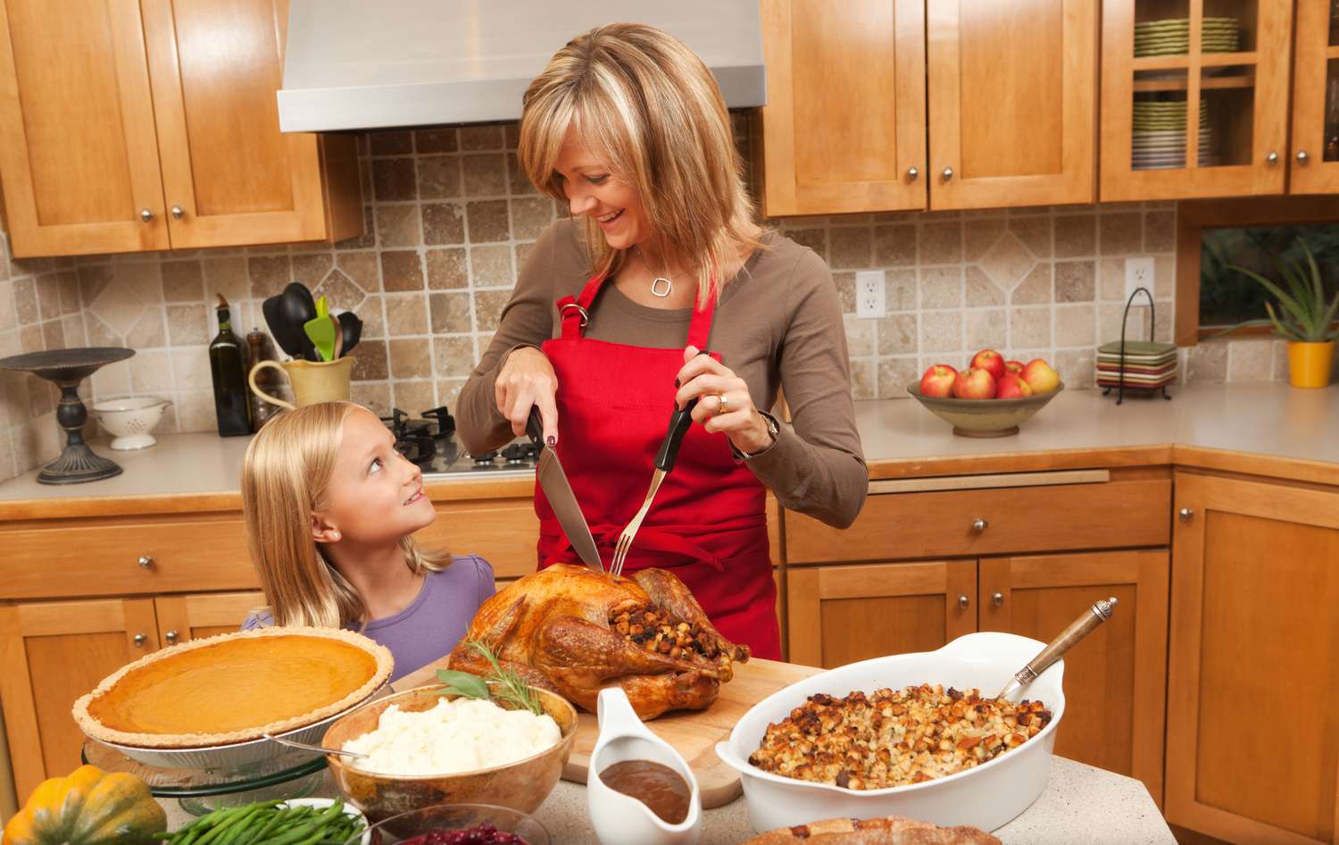 Mutter und Tochter tranchieren einen Truthahn in der Küche