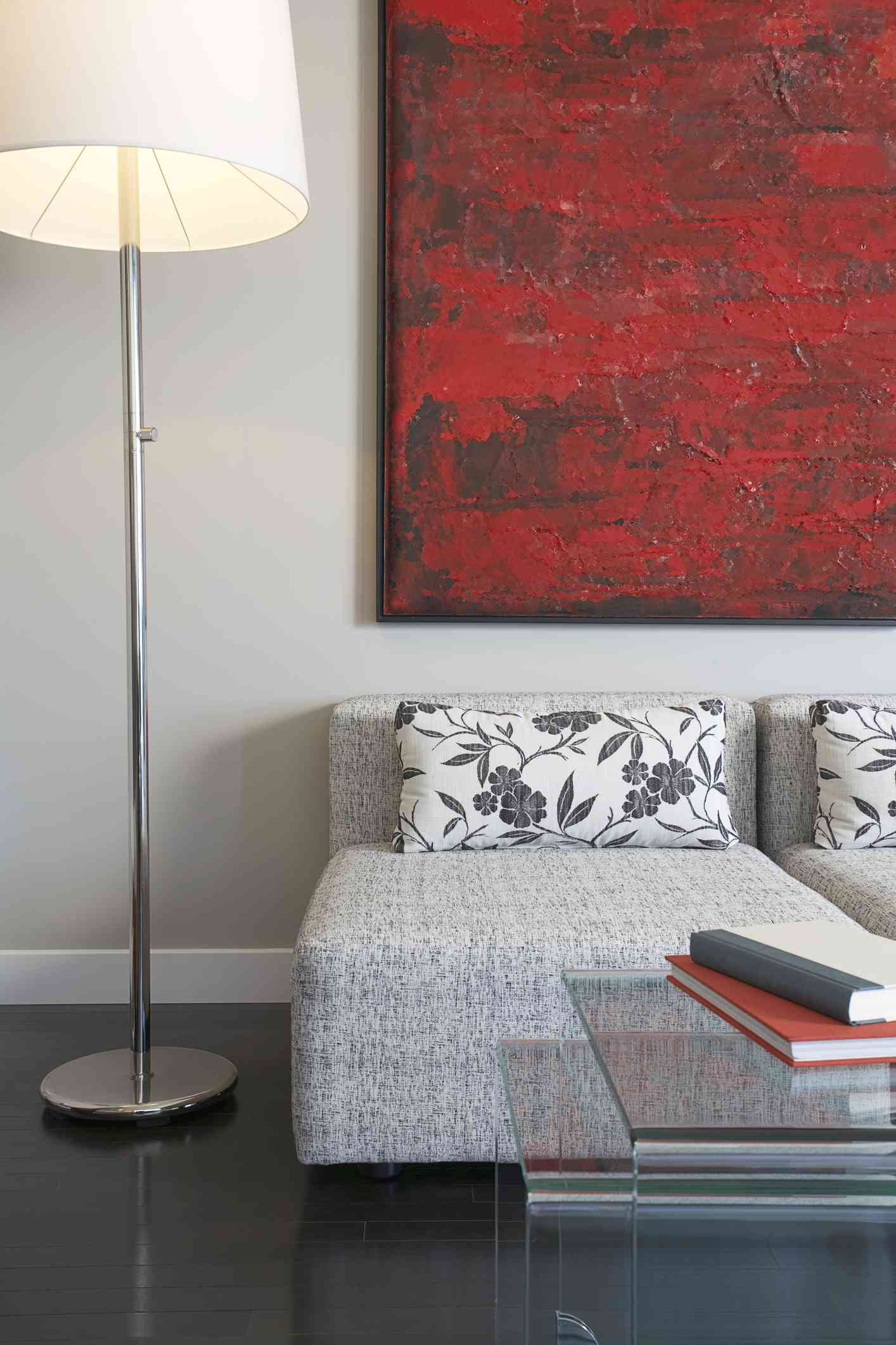 Salon avec canapé gris et art abstrait rouge et noir