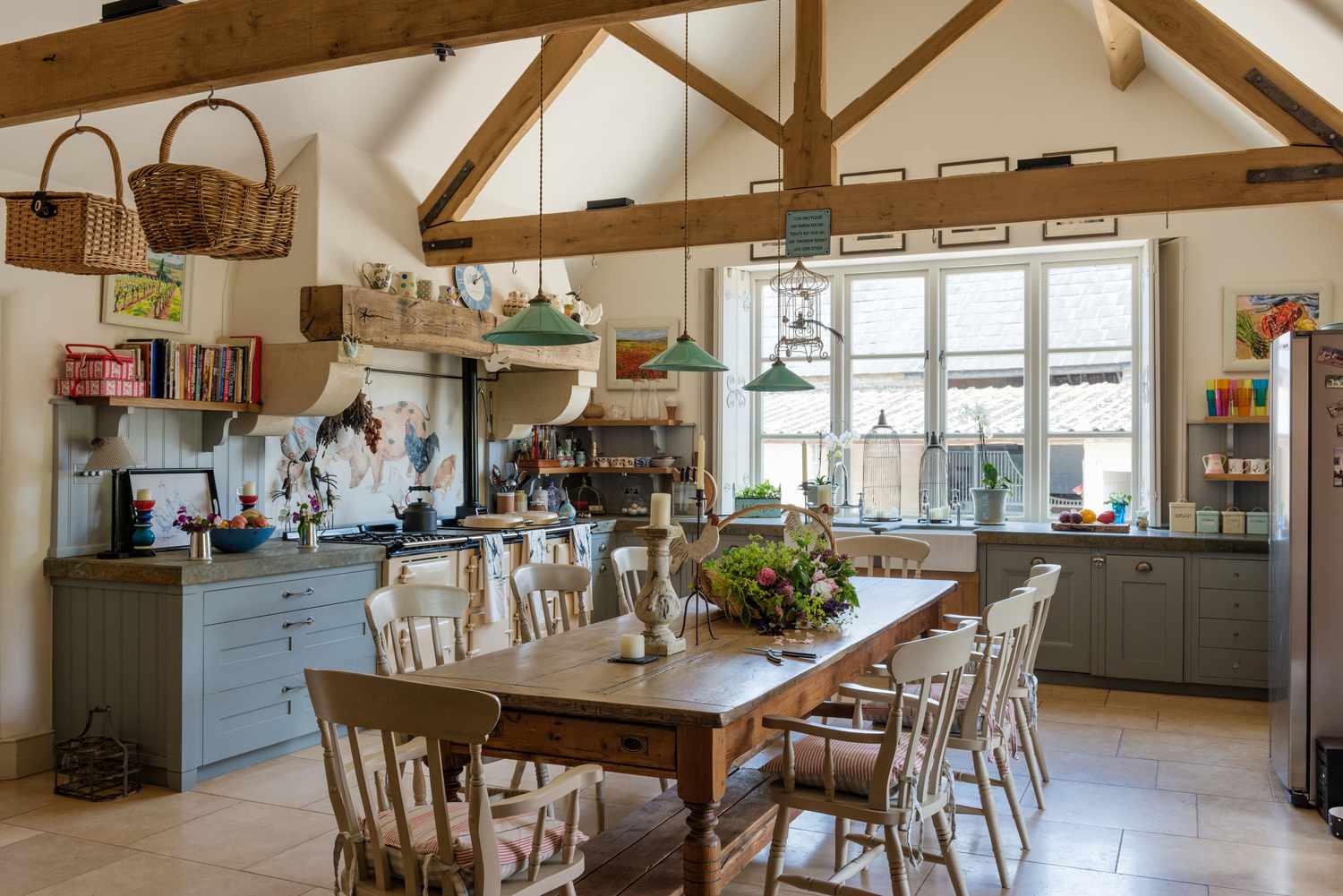 Mesa de fazenda vintage em uma cozinha rústica com luzes pendentes verdes da Holloways of Ludlow, aga e teto com vigas