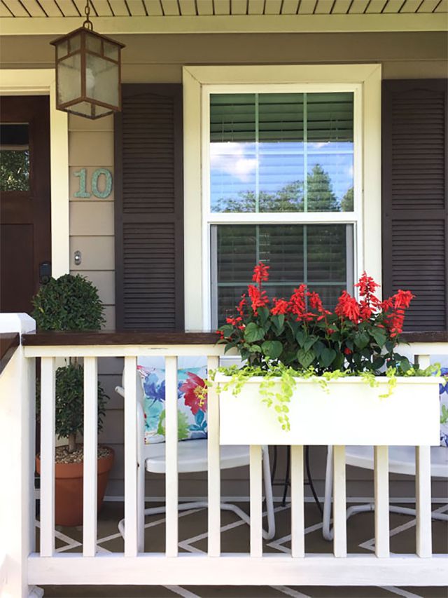 White porch planter with red flowers