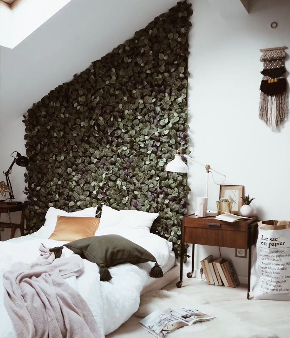 Chambre à coucher avec feuilles sur le mur derrière le lit