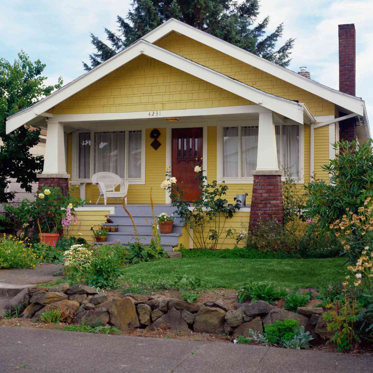 Gelbes Haus im Bungalowstil mit Garten, Außenansicht