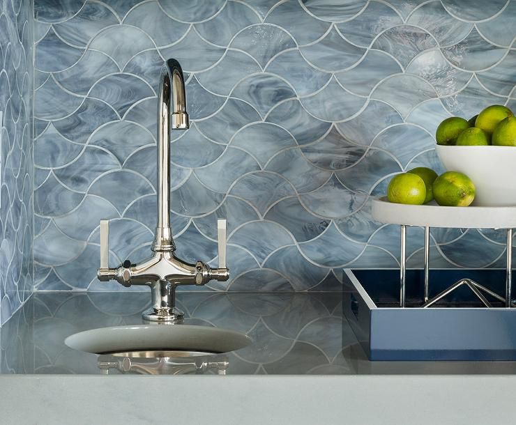 backsplash de mármol azul en forma de azulejos ondulados detrás de un fregadero plateado