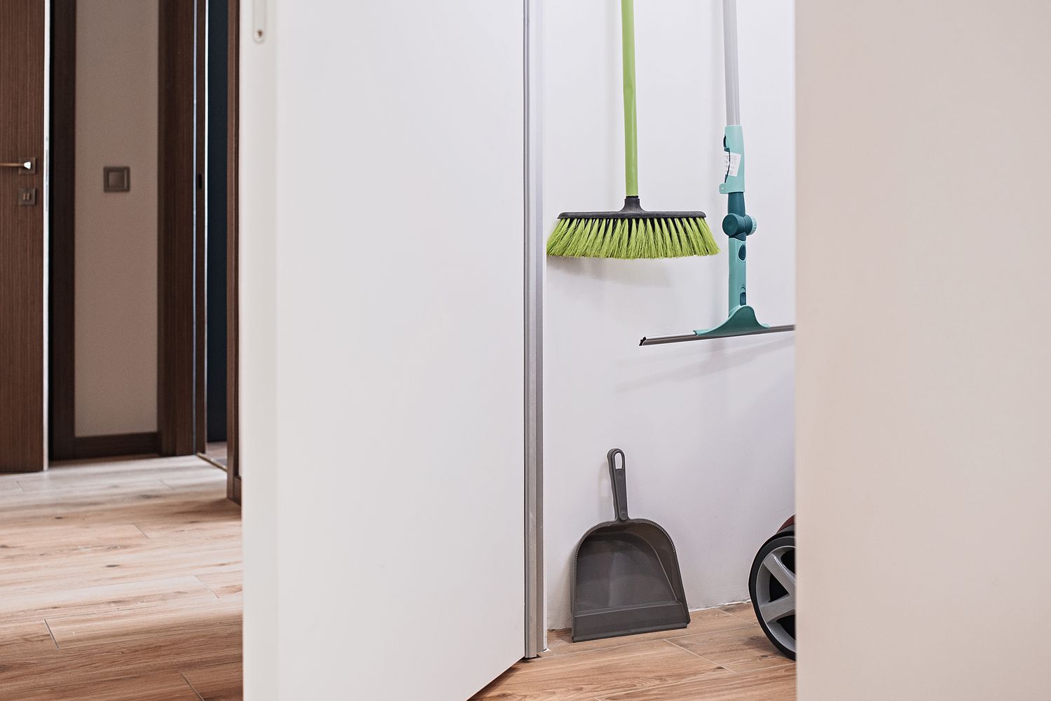 White closet with sweeping supplies stored inside