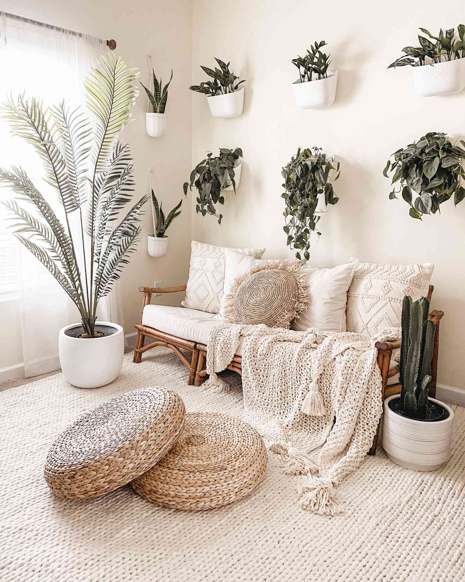 Plantas artificiais em toda esta sala de estar com uma decoração boho neutra