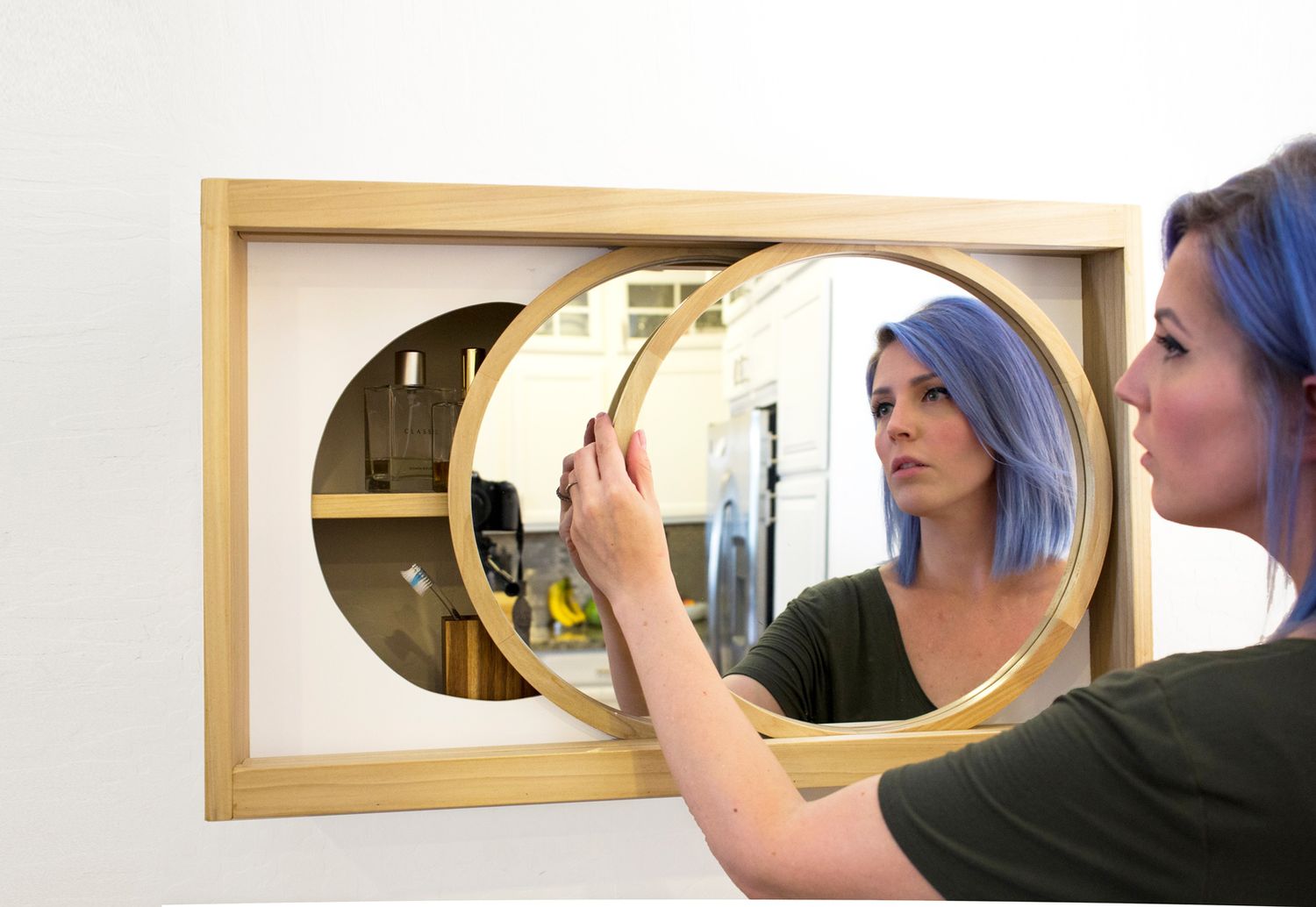 Elisha Albretsen abriendo armario de pared con espejo personalizado