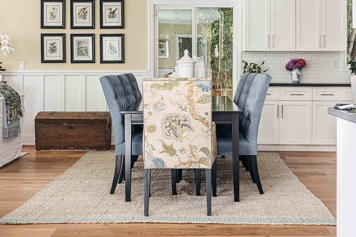 Large jute area rug underneath dining table with a patterned upholstered chair in center