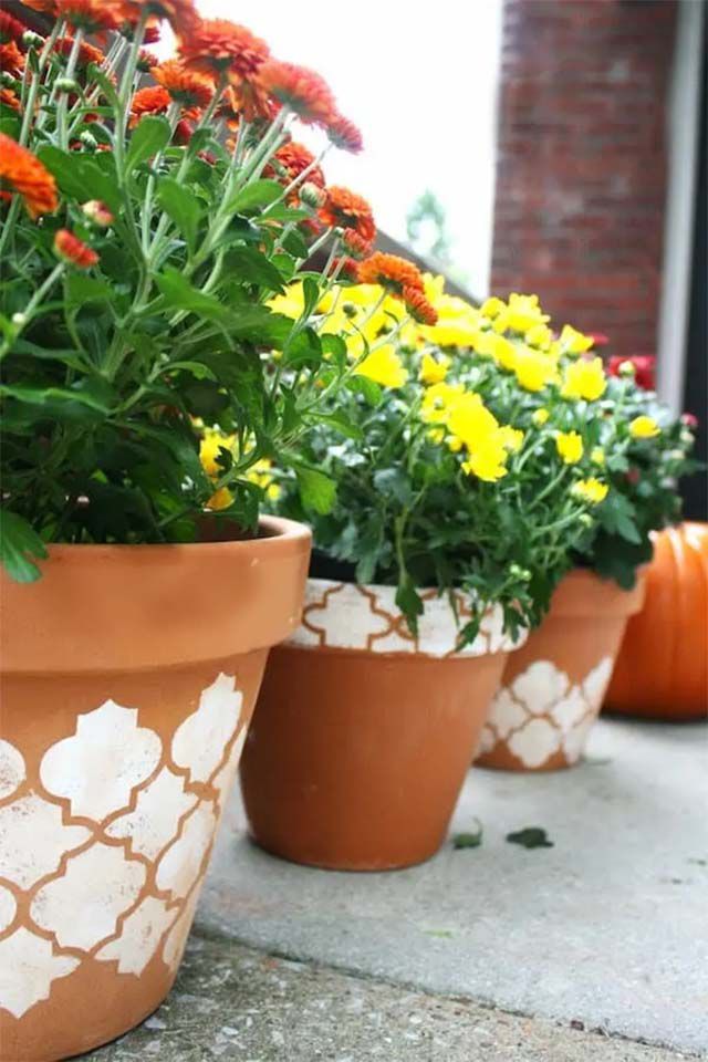 Un trío de macetas de terracota estarcidas con flores